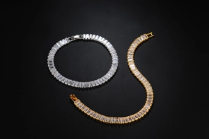 Close-up of gold and silver hip hop Cuban link bracelets with iced-out square zircon stones