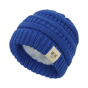 Detailed view of dark blue knit baby hat with soft white fleece lining and MOK label
