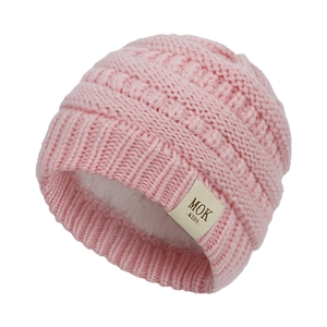 Detail of pink knitted baby beanie with warm fleece lining and brand label