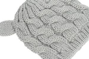 Detail view of light grey chunky knit baby hat with cable pattern and cute ear design