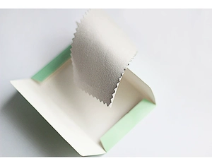 Detail of white jewelry gift box with silver polishing cloth and ribbon decoration