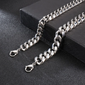 Close-up of polished silver Cuban link chain with lobster clasp on dark background