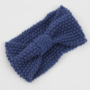 Detail of navy blue knitted headband featuring chunky corn kernel stitch and central knot