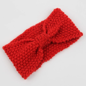 Detailed view of red chunky knit headband featuring a textured corn kernel pattern bow