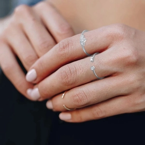 Detail of silver S925 rings set with sparkling zircon stones on female hand