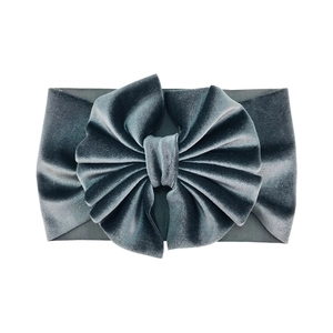 Detail of a large dark grey-blue velvet bow headband with soft texture and wide design