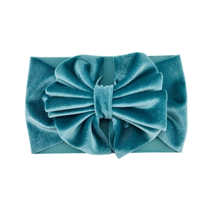 Macro detail of teal velvet baby headband showing soft fabric texture and large bow