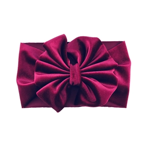 Macro detail of the wine red velvet baby headband with a large layered bow design