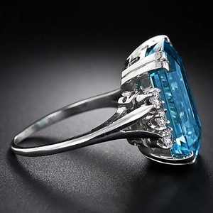 Ring met hemelblauwe edelsteen in smaragdslip en zilveren zetting met diamanten