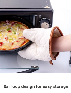 Detailed view of insulated quilted baking mitt taking a hot pizza out of the black oven