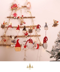 Close-up of wooden Christmas gnome and reindeer clips hanging on a festive twine string