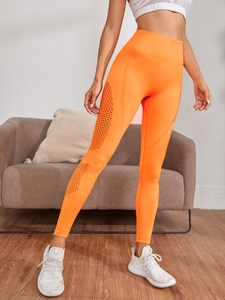Detail der nahtlosen orangefarbenen Yogahose mit hoher Taille und atmungsaktivem Mesh-Design