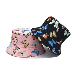 Detail of pink and black bucket hats featuring colorful butterfly patterns in cotton fabric