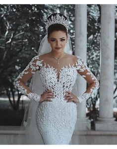 Détail d'une robe de mariée en dentelle à manches longues avec broderies florales