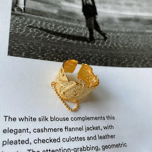 Macro detail of gold textured irregular ring with chain link detail on book page