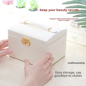 Detail view of a white PU leather jewelry box with golden lock on a wooden table