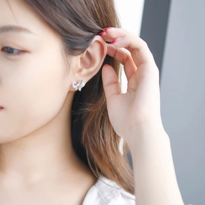 Elegant bow knot stud earrings with micro-set zircon stones on a model's ear