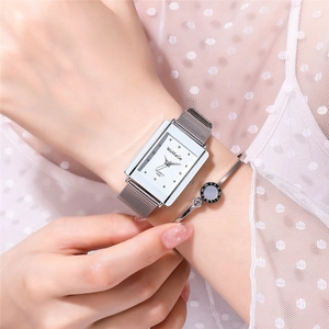 Detail of rectangular quartz watch with silver mesh band and matching roman numeral bracelet
