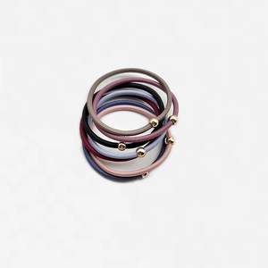 Dettaglio di elastici per capelli colorati con perline dorate lucide in 5 varianti di colore