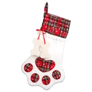Close-up of paw shaped Christmas stocking with red plaid accents and hanging bone charms