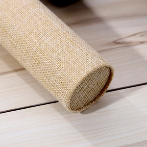 Macro shot of beige linen fabric texture and stitching on a cylindrical jewelry display