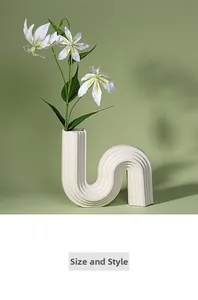 Détail d'un vase en céramique blanc en forme de U avec texture nervurée et fleurs
