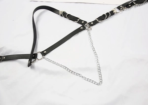 Detail of gothic punk body chain with black leather straps and silver metal rings
