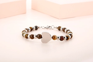 Detailed view of beaded bracelet with tiger eye stones and a polished heart pendant