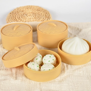 Miniature steamed bun toy set with plastic steamers on beige linen background