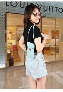 Detail view of light blue PU leather phone bag with a gold metal buckle and strap