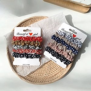 Lot de 5 chouchous en satin avec motifs floraux et à pois dans un plateau tressé