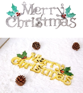 Detail of gold and silver Merry Christmas signs with holly leaves and red berry accents