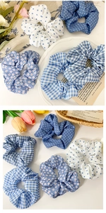 Détail de chouchous bleus à fleurs, pois et carreaux sur un fond esthétique blanc pur