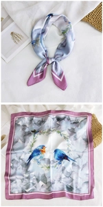Detail showing blue bird and floral patterns on an elegant silk-like square scarf