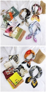 Detail showing various printed silk scarves with floral and geometric patterns on linen