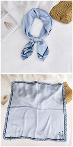 Detail of light blue silk square scarf with plaid border and minimalist cartoon print