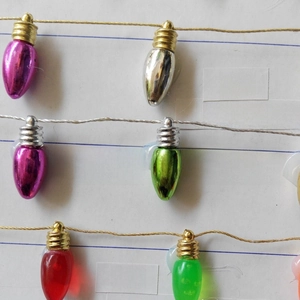 Close-up of multicolored plastic Christmas bulb pendants with electroplated finish