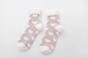 Close-up of soft coral fleece texture on light purple socks with white heart patterns
