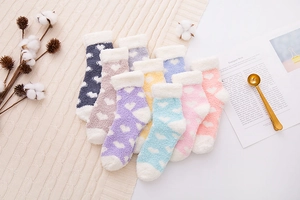 Flat lay of soft coral fleece heart socks in pastel colors with white plush cuffs