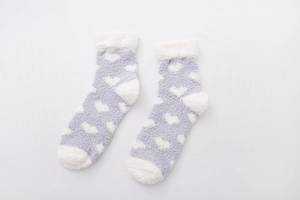 Detail of soft gray coral fleece socks with white heart patterns and fuzzy texture