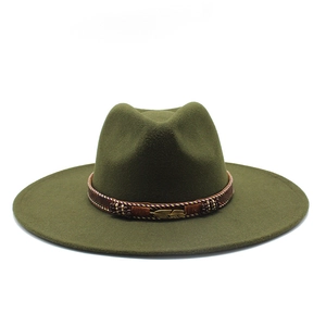 Detail of olive green wool fedora featuring a woven brown band and gold feather pin