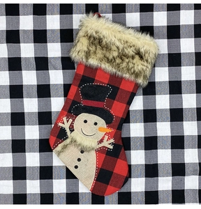 Détail d'une chaussette de Noël en toile avec motif à carreaux et bonhomme de neige