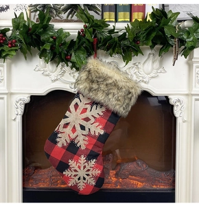 Gros plan sur une chaussette de Noël à carreaux avec fausse fourrure et flocons