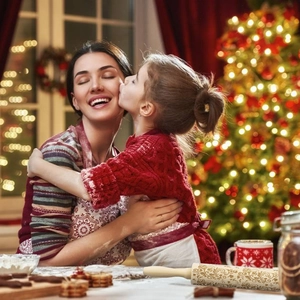 Family baking scene showing a Christmas themed embossed wooden rolling pin for cookies