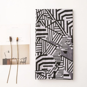 Flat lay of lightweight summer scarf with black and white abstract geometric pattern