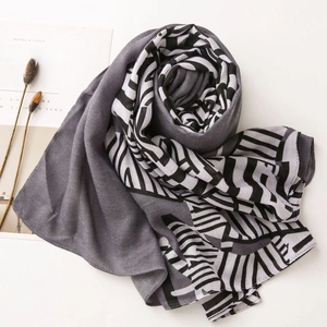 Macro shot of grey and black geometric striped thin scarf with a minimalist magazine