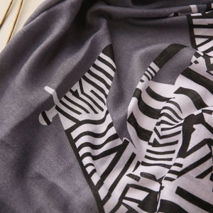 Detail of soft grey scarf fabric with black and white zebra pattern and fine texture