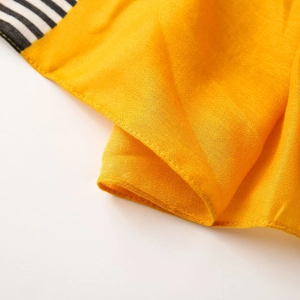 Macro shot of yellow cotton linen scarf fabric showing fine texture and striped edge