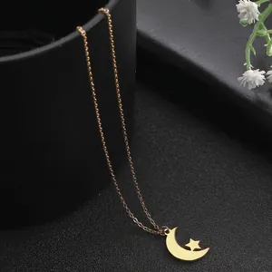 Golden stainless steel necklace featuring a hollow moon and star pendant on a cross chain