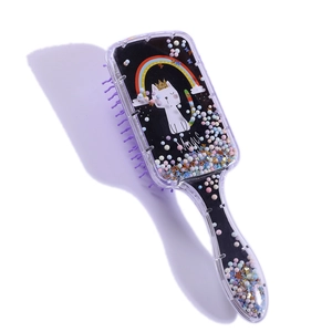 Detail of cartoon cat hairbrush with liquid glitter stars and purple bristles